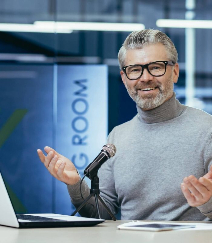 successful-mature-financier-business-coach-teacher-working-inside-office-with-laptop-and.jpg
